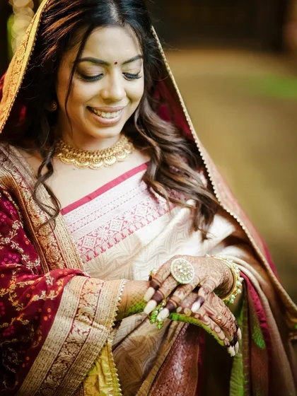 A candid shot of the bride in a beautiful saree, admiring her henna.