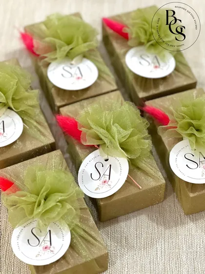 These small gift boxes are wrapped in gold glitter paper and topped with a green tulle pom-pom and a personalized initial tag. They are perfect as festive favours or for a glamorous party.