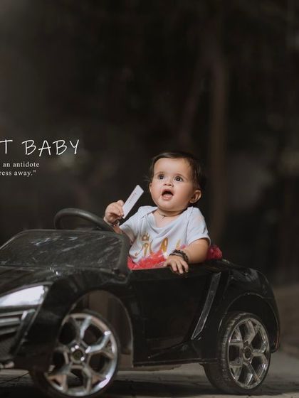 My sweet baby. A dramatic, low-key outdoor portrait of a baby in a toy car at dusk.