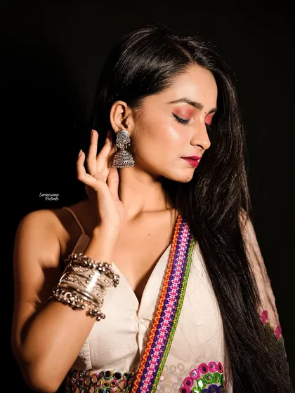 A close-up on Navratri elegance, highlighting the oxidized silver jewelry and the intricate embroidery of the lehenga against the model's graceful pose.