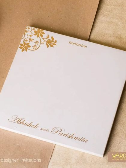 This simple yet beautiful wedding invitation features elegant gold script and a delicate floral motif on a clean white background. It's a perfect choice for couples seeking understated elegance and classic design.
