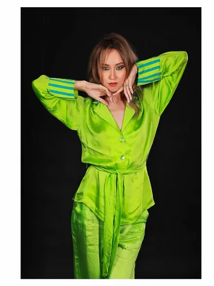 A fashion shot for the sleepwear and loungewear brand LSTSOLES. The pose and lighting are designed to showcase the vibrant color and comfortable fit of the satin co-ord set.
