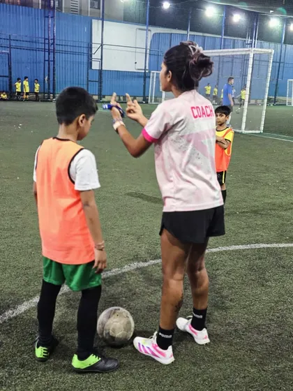 "Coaching with kindness, leading with heart." Coach Shruti giving one-on-one instructions to a player, demonstrating our focus on individual attention and positive reinforcement.