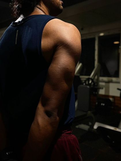 This photo was taken on day four of a client's lean bulking journey, focusing on triceps. The visible muscle definition in his arm is a direct result of our targeted triceps workout and nutrition plan.