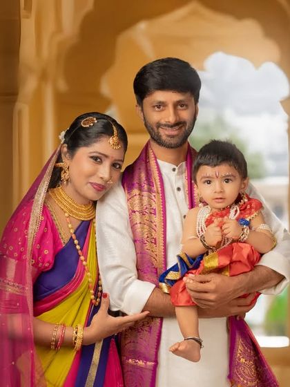 A complete family portrait from the same traditional-themed session. The family stands together in a beautiful arched hallway, creating a formal yet warm photograph that can be treasured for years.