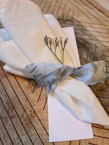A finished napkin, elegantly tied with a scrap of naturally dyed fabric. This is a beautiful and sustainable way to present a handmade gift.