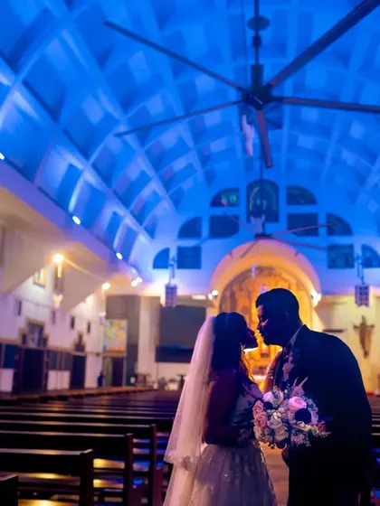 A 'just married' silhouette against the striking blue light of the church ceiling. This shot uses color and shadow to create a modern, dramatic portrait that captures the quiet, intimate moment after the ceremony.