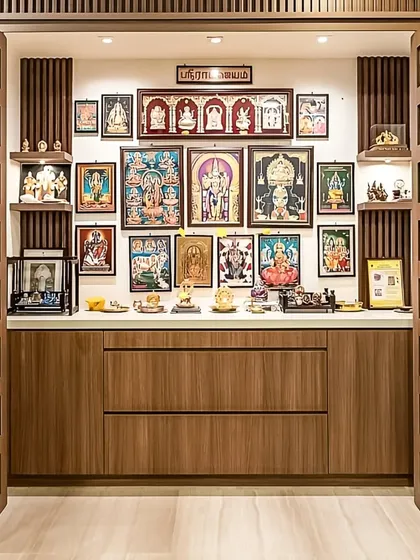 This traditional pooja room is designed as a serene and sacred space within the home. Custom wooden doors with intricate cutouts open to reveal a well-organized area for idols and prayer essentials, complete with focused lighting.