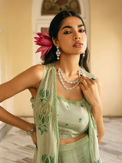 A detailed close-up of a three-piece ethnic set, focusing on the unique lotus embroidery and the layered styling. This shot is perfect for highlighting a collection's signature craftsmanship.