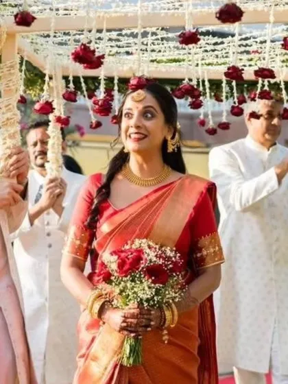 The pure joy of a bride on her wedding day. Her red Kanjeevaram, which I had the honor of pre-pleating, moves beautifully with her as she walks under the floral canopy.