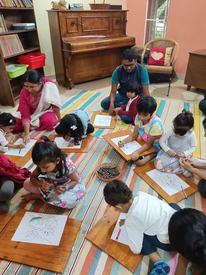 The children are deeply focused on coloring their ghariyals, each adding their own unique touch.