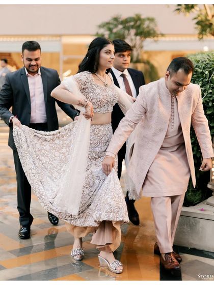 The bride making her entrance at the Roka ceremony, her brothers helping with her elegant lehenga.