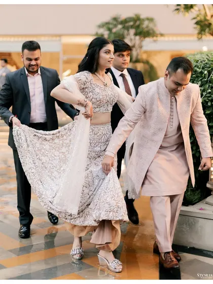 The bride making her entrance at the Roka ceremony, her brothers helping with her elegant lehenga.