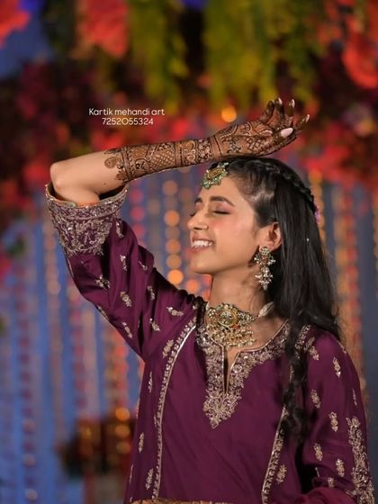 A candid, joyful moment of a client showing off her full-arm mehandi. Our designs are made to look great from every angle, even in motion.