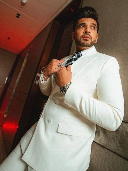 A different angle of Karan Kundrra in the white suit, adjusting his tie. It shows how a bespoke suit moves with you and looks great from every perspective.