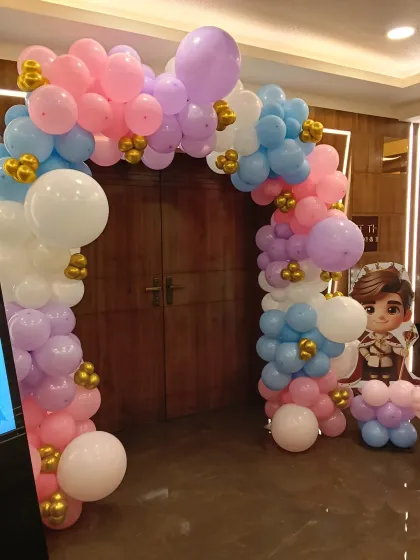 Welcome your guests in style with a beautiful balloon arch. This entrance decoration for a princess-themed party uses a soft pastel palette of pink, blue, and lavender with gold accents, setting a magical tone right from the door.