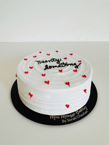 Some designs are worth repeating. This 'twenty something' cake with tiny red hearts is a customer favorite for its simple, clean, and relatable message.