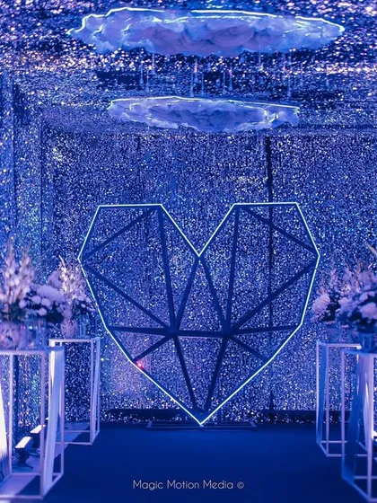 We love creating immersive entrances. For this celestial-themed Sangeet, we built a 'Tunnel of Love' with thousands of glittering blue sequins, a geometric heart, and floating clouds to transport guests into another world.