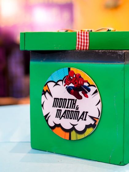 A personalized centerpiece box for a superhero party, featuring Spiderman and Avengers logos.