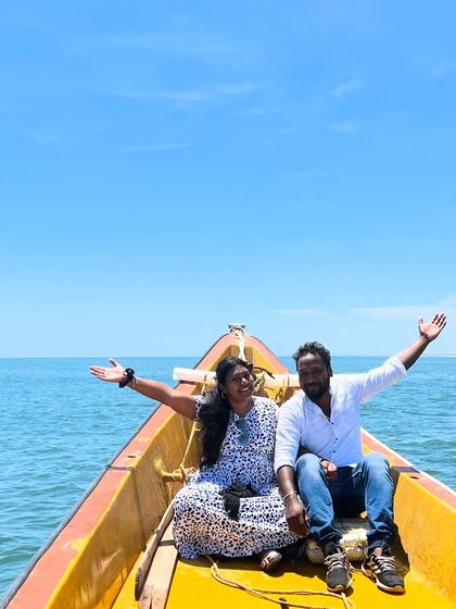 A couple enjoying the freedom and joy of a private boat ride, with endless blue sea and sky around them.