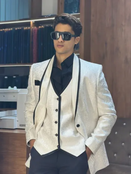 The full look of the white textured tuxedo. Paired with black trousers and a black shirt, it creates a striking black and white contrast that is both classic and bold.