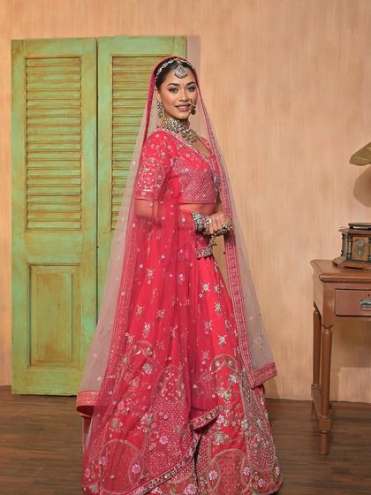 A full-length view of a model in a stunning pink lehenga, set against a vintage-inspired backdrop. My outfits are perfect for creating themed photoshoots.
