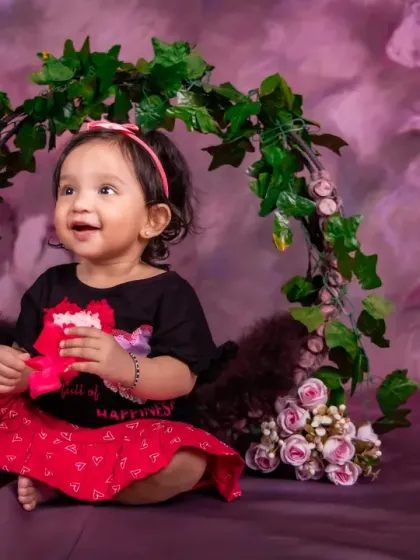 A simple and beautiful portrait using a floral ring prop against a soft, painted backdrop.
