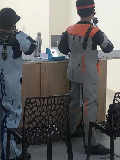 Two young rifle shooters in their custom jackets during a practice match.