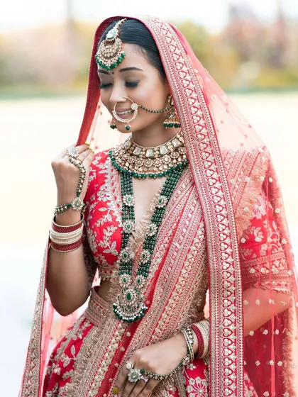 The delicate veil frames her face beautifully. The makeup is flawless, with a focus on enhancing her natural features to create a look that is both traditional and personal.