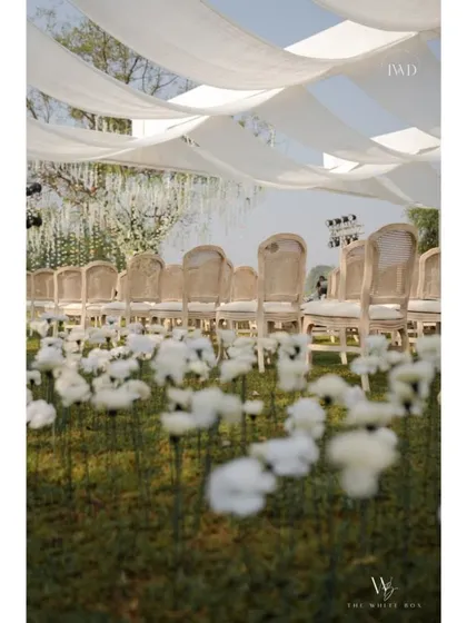 Another view of the whimsical flower field and elegant seating under a draped canopy. The entire setup was designed to feel soft, romantic, and dream-like.