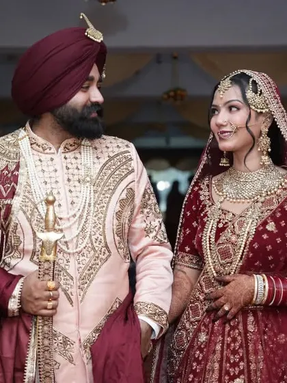 The couple captured during their walk, the groom holding a kirpan, showcasing a traditional element of a Sikh wedding.