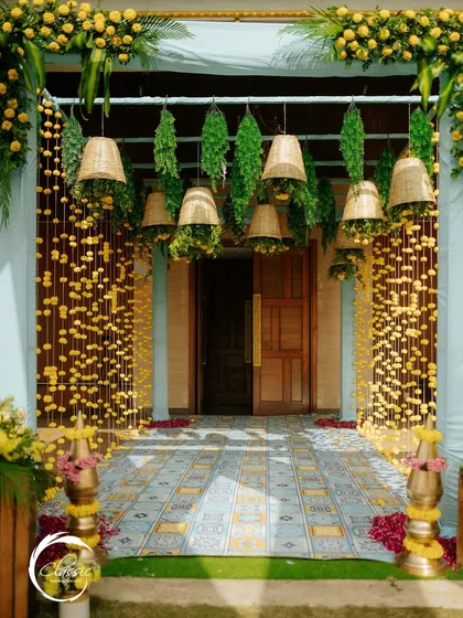 For a traditional Haldi or Mehendi, I created this charming entrance using strings of marigolds, hanging wicker baskets, and a patterned tile floor to give it a rustic and authentic desi feel.