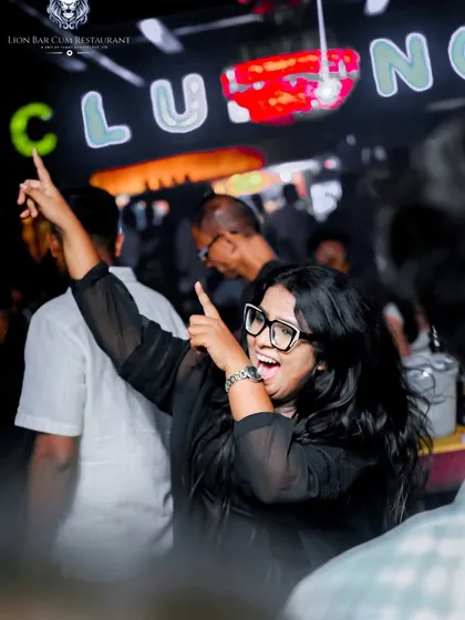 A partygoer at Lion Bar pointing right back at the DJ booth, feeling the connection.