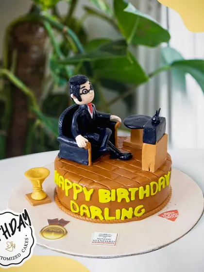 A special cake for a husband, featuring a fondant figure relaxing in his favorite armchair. A sweet and personal way to celebrate his birthday.