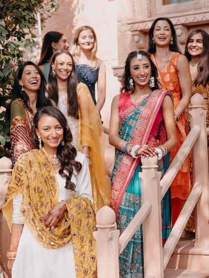 The bride's squad looking radiant against the backdrop of the historic fort during the colorful Haldi event.