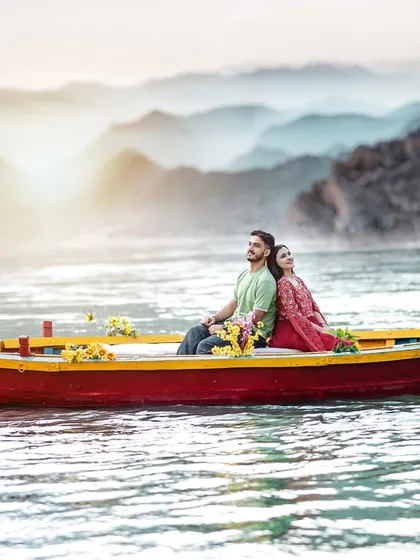 A serene shot of a couple in a traditional boat on the misty waters of Rishikesh. The soft light and calm atmosphere make for a dreamy and romantic pre-wedding picture.