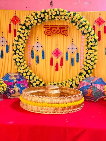A traditional and vibrant Haldi ceremony stage. This setup features a bright yellow backdrop, a full arch made of fresh genda phool (marigolds), and decorative hangings to create the perfect festive atmosphere for pre-wedding functions.