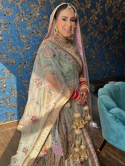 A happy bride glowing in the sunlight. Her pastel green lehenga and soft, natural makeup create a fresh and beautiful look for her daytime wedding.