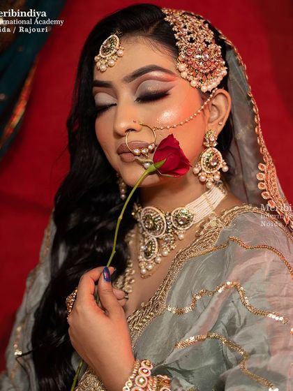 This Pakistani bridal look features soft, smokey eyes and a muted lip color, creating a look of timeless elegance. The side jhoomar is a key element you'll learn to style.