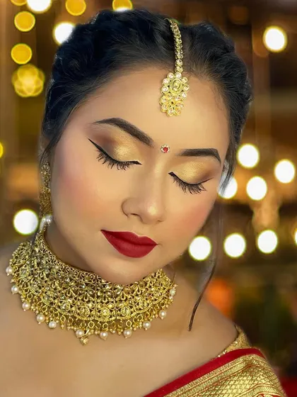 A timeless bridal look featuring soft golden eyes and a classic red lip. The focus here is on flawless skin and elegant lashes that add definition without overpowering the look, creating a perfect picture of grace.