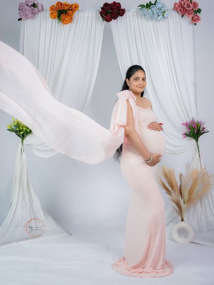 A dynamic solo portrait with the fabric of the pink gown tossed to the side. This technique adds energy and a high-fashion feel to the maternity shoot.