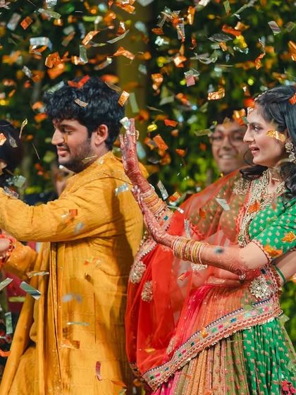 A beautiful shot of the bride and groom dancing amidst their family during the finale. The confetti adds a magical touch to this happy moment.