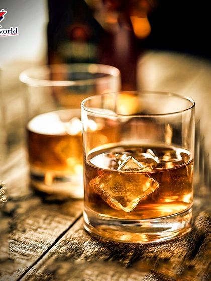 A close-up of our handcrafted libations. The warm glow on the whiskey glasses invites you to sit back, relax, and elevate your evening with a quality drink.