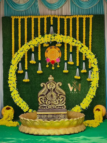 For this Haldi ceremony, we created a traditional yet elegant backdrop. The setup features a lush green wall, a circular arch made of bright yellow marigolds, and a decorative antique-style urn, perfect for this auspicious occasion.