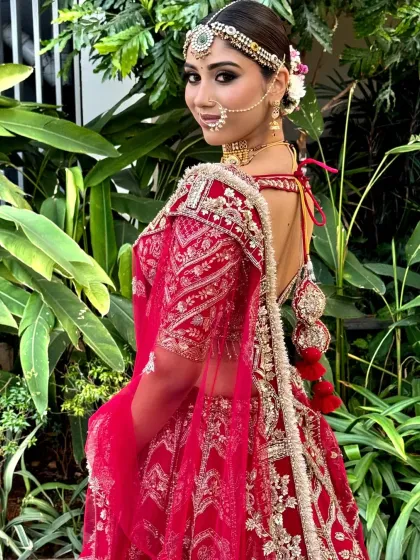 A model showcasing a classic bridal look with a neat bun adorned with fresh flowers. This hairstyle is ideal for a bride who wants a timeless and elegant appearance.