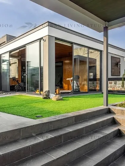 A wide view of our Aligarh project, showcasing how we design complete outdoor ecosystems. This space includes a glass-enclosed gym, a covered lounge area, and manicured lawns, all connected by thoughtfully designed pathways and multi-level structures.