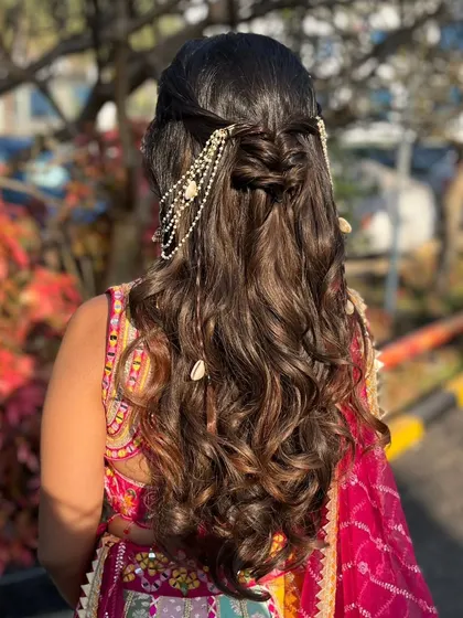 A beautiful half-up hairstyle with a pearl and shell-detailed accessory. This is a great way to add a touch of beachy elegance to your look.