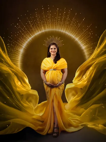 A regal portrait for a radiant mother-to-be, captured with a stunning golden halo effect and a flowing yellow gown. This is our signature queen-style maternity shoot, designed to make you feel like royalty.