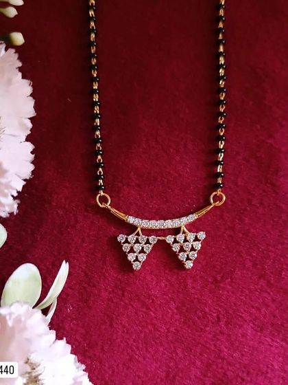 A chic and geometric mangalsutra design, this piece features two small triangles made of American diamonds. It's a modern and minimalist take on the traditional necklace.