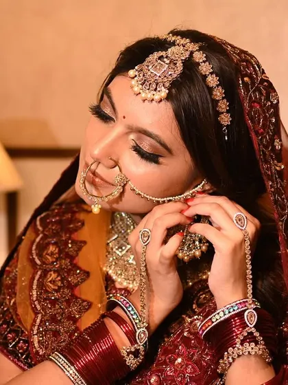 Adjusting the nath is a classic bridal moment. This candid-style shot feels intimate and real, adding a human touch to a commercial bridal photoshoot while still showcasing the jewelry and makeup.